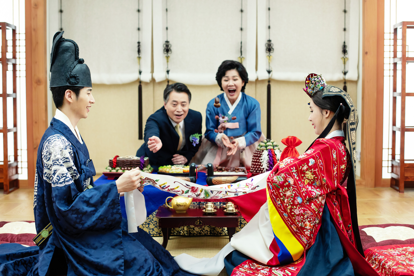 A stock photo of parents, center back, tossing dates and chestnuts for a newlywed groom and bride to catch. The number of dates and chestnuts caught by the couple are taken to symbolize the number of daughters and sons they will bear. [GETTY IMAGES]
