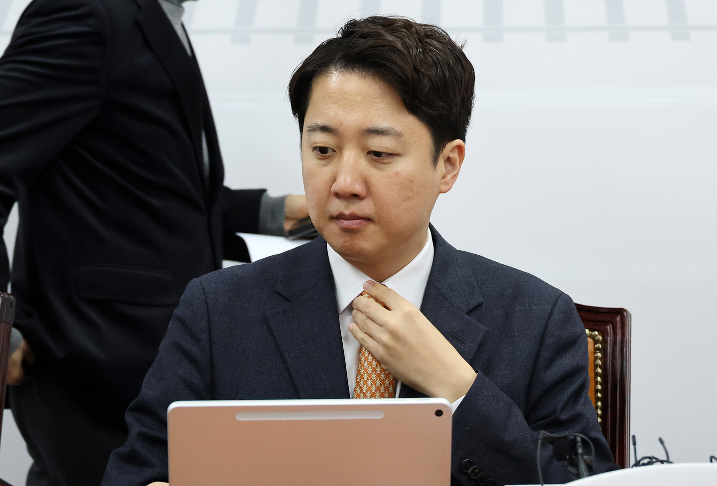 Reform Party leader Lee Jun-seok adjusts his tie ahead of a supreme council meeting at the National Assembly in western Seoul on Dec. 15. [YONHAP]