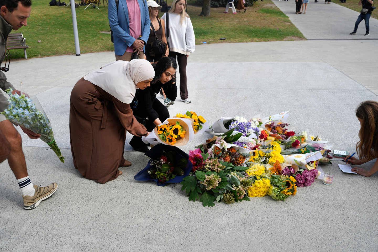 Women place flowers and leave notes at a memorial outside Bondi Pavilion at Sydney's Bondi Beach, Dec. 15, a day after a shooting. [AP/YONHAP]