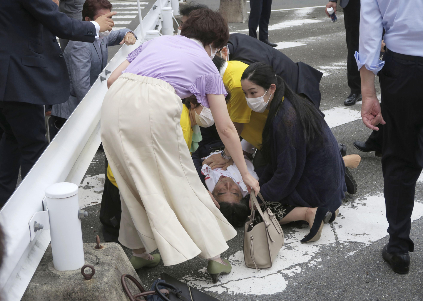 Japan’s former Prime Minister Shinzo Abe, center, falls on the ground after being shot during a campaign speech in Nara, western Japan, on July 8, 2022. [AP/YONHAP]