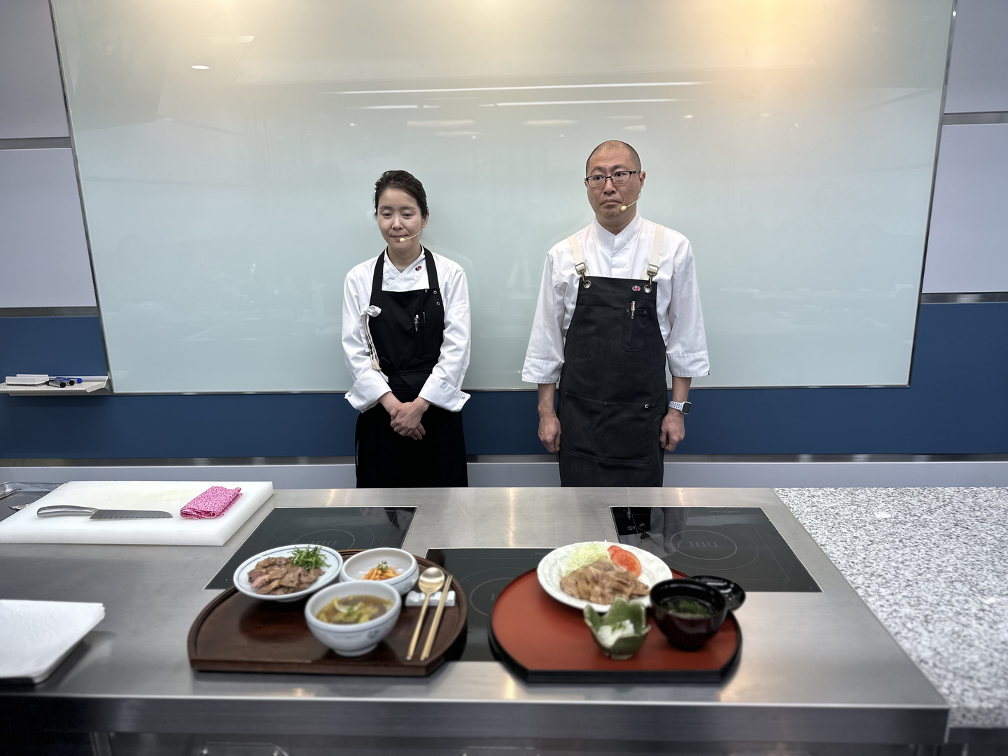 Hisaki Matsumoto, the resident chef at the Embassy of Japan in Korea, right, and Kim Ji-young, the owner and chef of the Korean dining restaurant Gyuban, pose with the dishes they made during a home-style cooking session at the Nakamura Academy in Gangnam District, southern Seoul, on Dec. 15. [SEO JI-EUN]