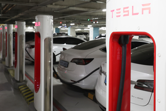 Teslas are charged at a station in downtown Seoul. [YONHAP]