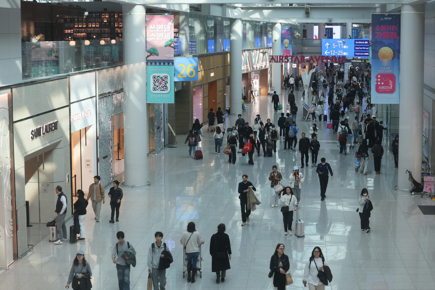 Travelers walk and shop inside the duty-free area of Terminal 1 at Incheon International Airport on Nov. 6. [YONHAP]