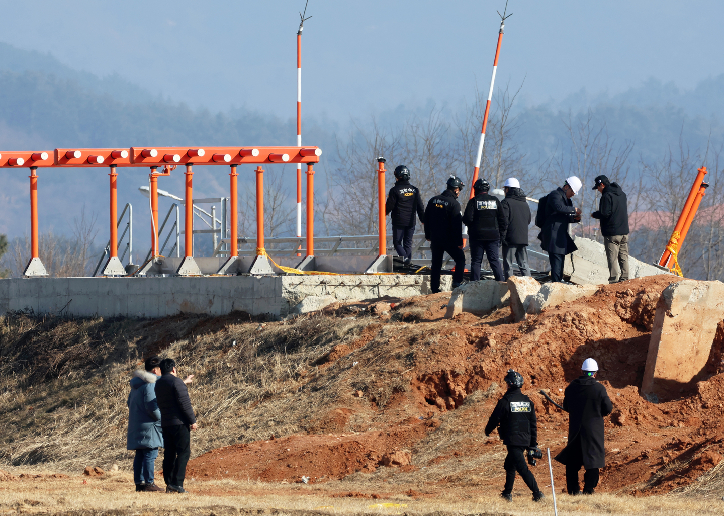 Investigators including officials from the Aviation and Railway Accident Investigation Board, police and families of the victims of the Jeju Air crash inspect a localizer at Muan International Airport in South Jeolla on Feb. 26. [YONHAP]