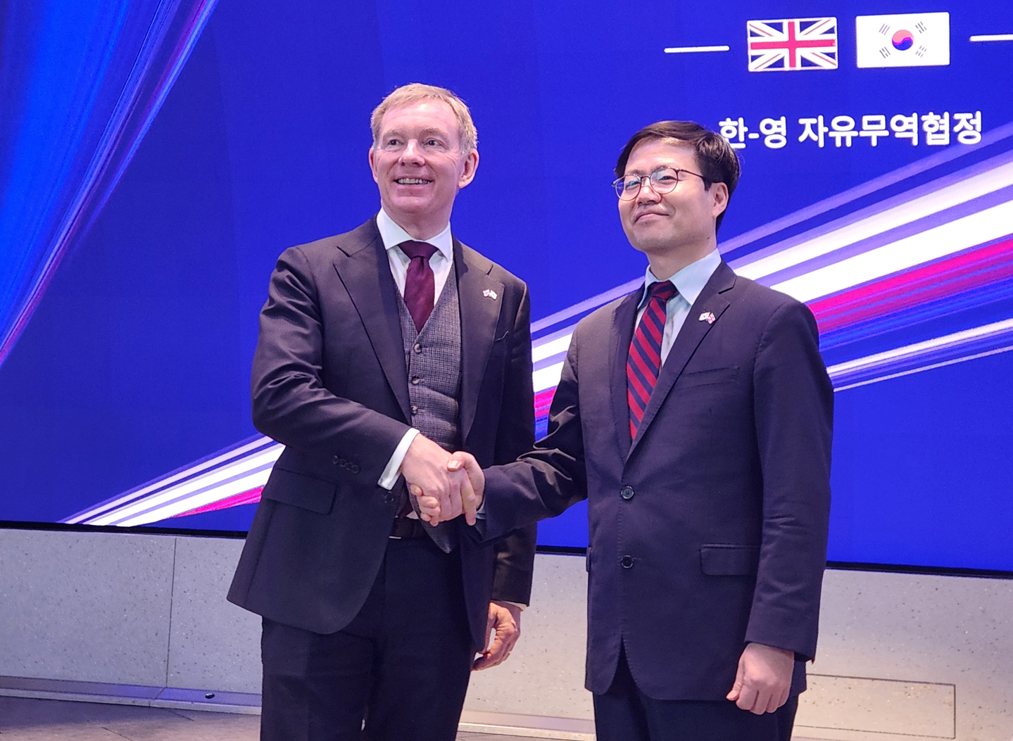 Yeo Han-koo, right, trade minister at the Ministry of Trade, Industry and Resources, and Chris Bryant, minister of state at Britain's Department for Business and Trade, pose for a photo in London on Dec. 15 after announcing the conclusion of talks to improve the Korea-Britain free trade agreement. [YONHAP]