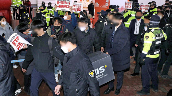 National Intelligence Service officers walks out of the headquarters of the Korean Confederation of Trade Unions in central Seoul after their raid for a National Security Act violation case in 2023. [NEWS1]
