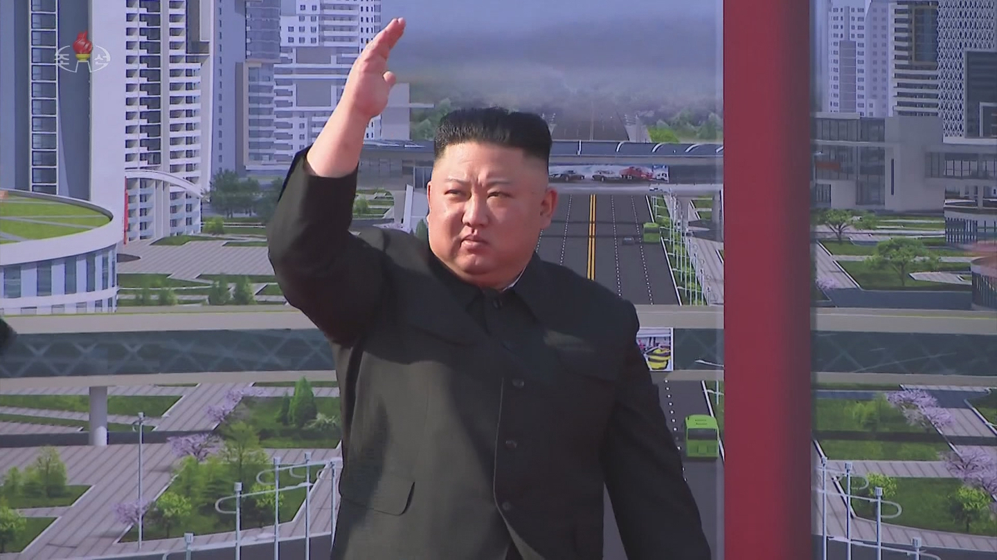North Korean leader Kim Jong-un waves to construction workers during a groundbreaking ceremony for a 10,000-unit housing project in Pyongyang on March 23, 2021, as reported by Korean Central Television the following day. [SCREEN CAPTURE]