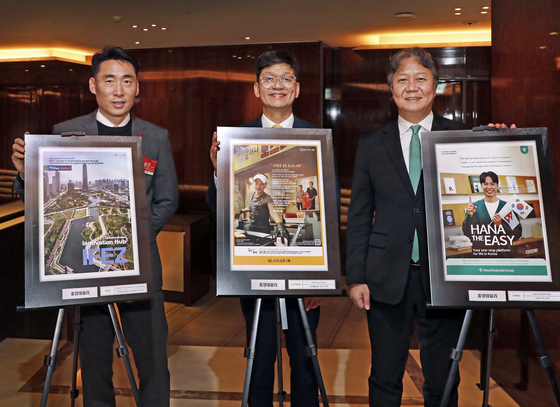 Recipients of the Korea JoongAng Daily's Advertising Awards pose for a photo with their advertisement papers at the ceremony held at Westin Josun Seoul in central Seoul on Dec. 16. From left, Park Sang-kon, the head of the press team at the Incheon Free Economic Zone Authority; Park Jin-young, chief public relation officer at the KB Financial Group, Kim Gi-hong, executive vice president of Hana Financial Group. [PARK SANG-MOON]