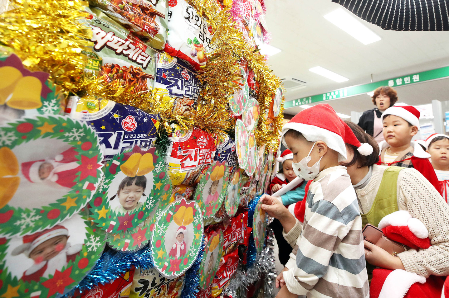 Children from local daycare centers make a Christmas tree using donated instant noodles at a donation ceremony for public daycare centers at Gwangju on Dec. 17. [GWANGJU CITY]