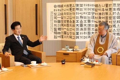 Unification Minister Chung Dong-young, left, talks to Na Sang-ho, head of Won Buddhism, during a meeting in Seoul on Dec. 17, in this photo provided by the Ministry of Unification. [YONHAP 