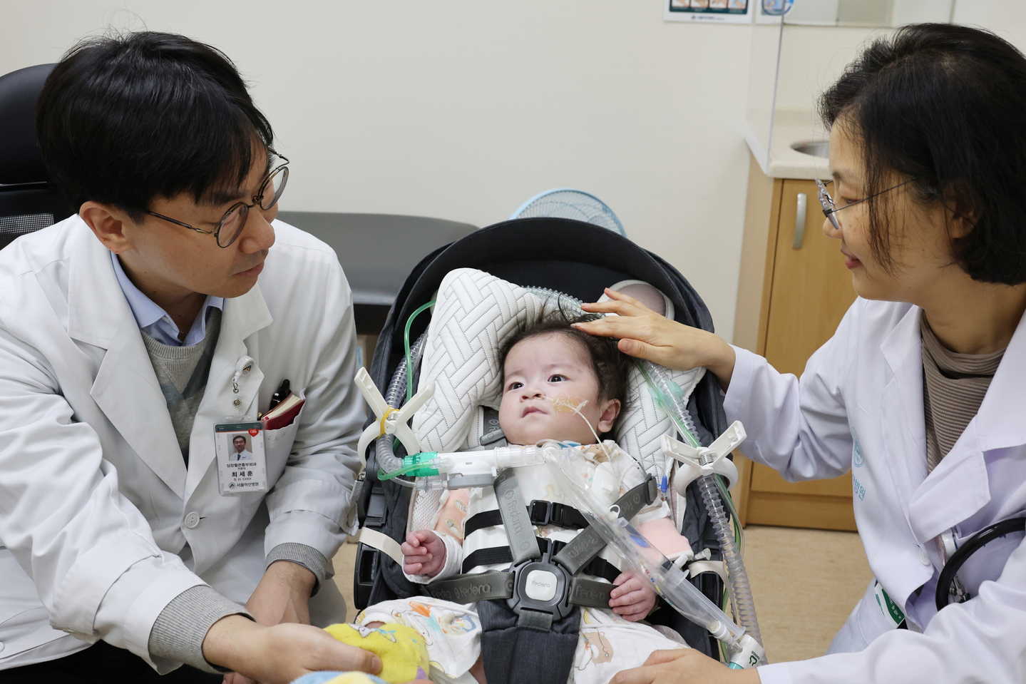 Eight-month-old Park Seo-rin, who was born with an exposed heart, is surrounded by doctors who performed the procedures at Seoul Asan Medical Center [SEOUL ASAN MEDICAL CENTER]