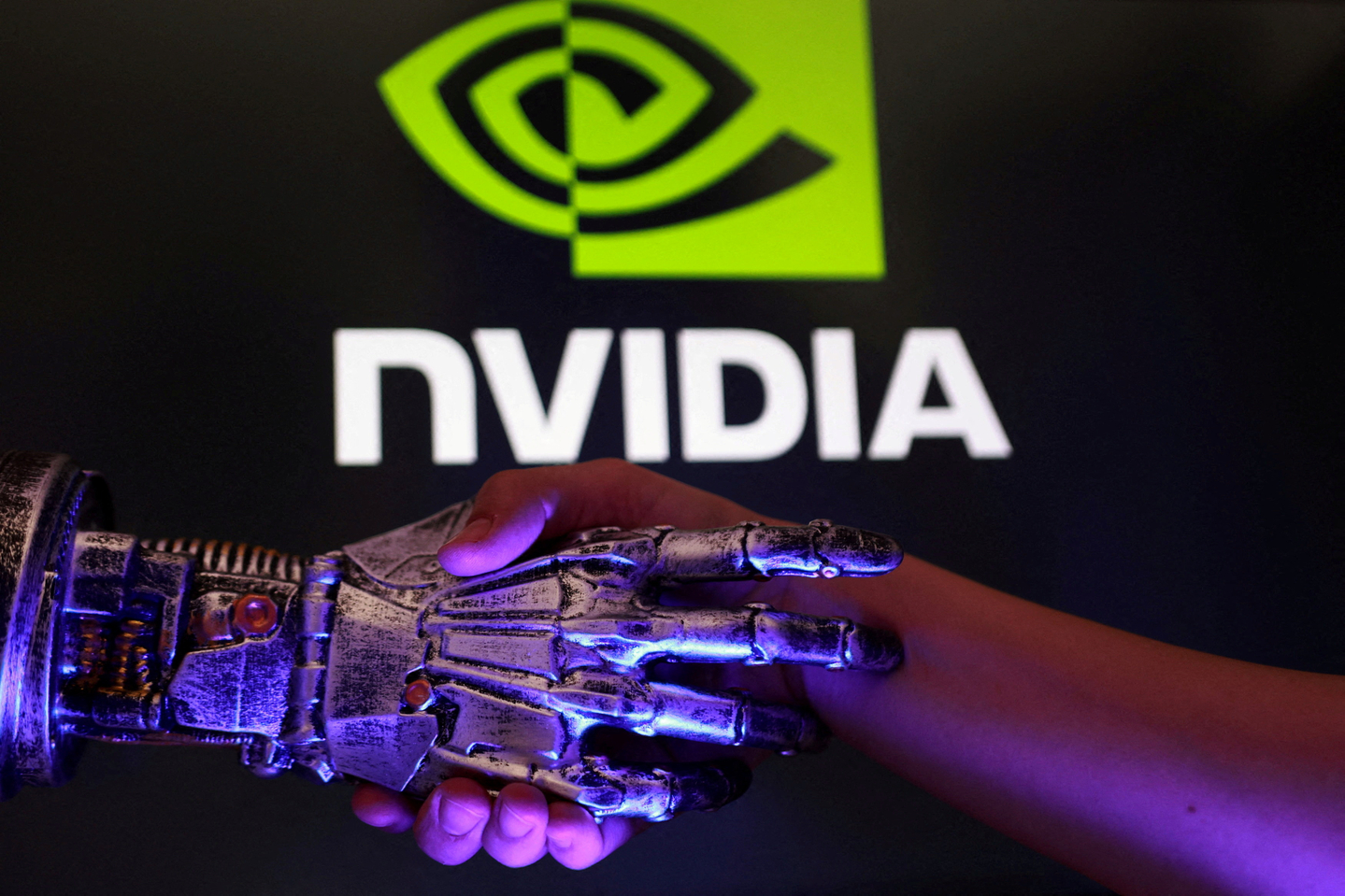 The Nvidia logo, a human hand and a 3-D-printed robot hand, is seen in this illustration from Aug. 27. [REUTERS/YONHAP]