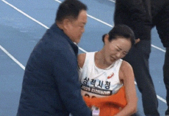 Runner Lee Su-min of the Samcheok City Hall team, the women’s domestic winner of the 2025 Incheon International Marathon, pushes past her coach Kim Wan-gi after crossing the finish line on Nov. 23 as seen in this video uploaded to YouTube. [SCREEN CAPTURE]