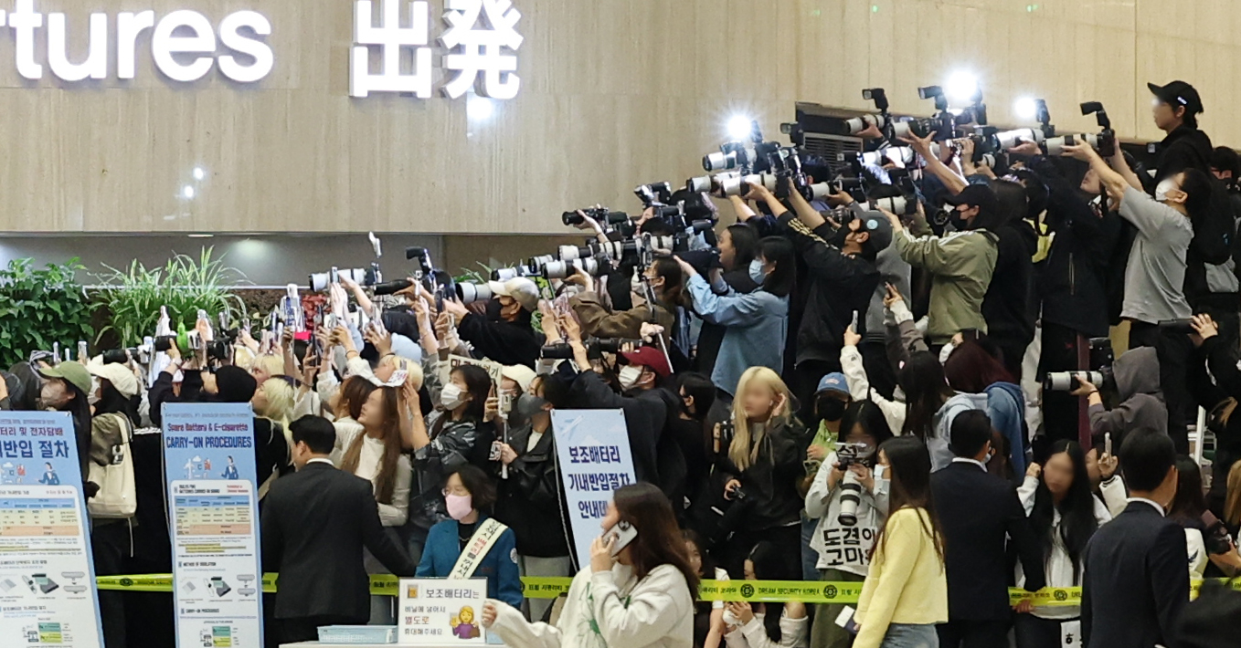Fans take photos of boy band Seventeen before their flight at Gimpo International Airport on May 9. [NEWS1]
