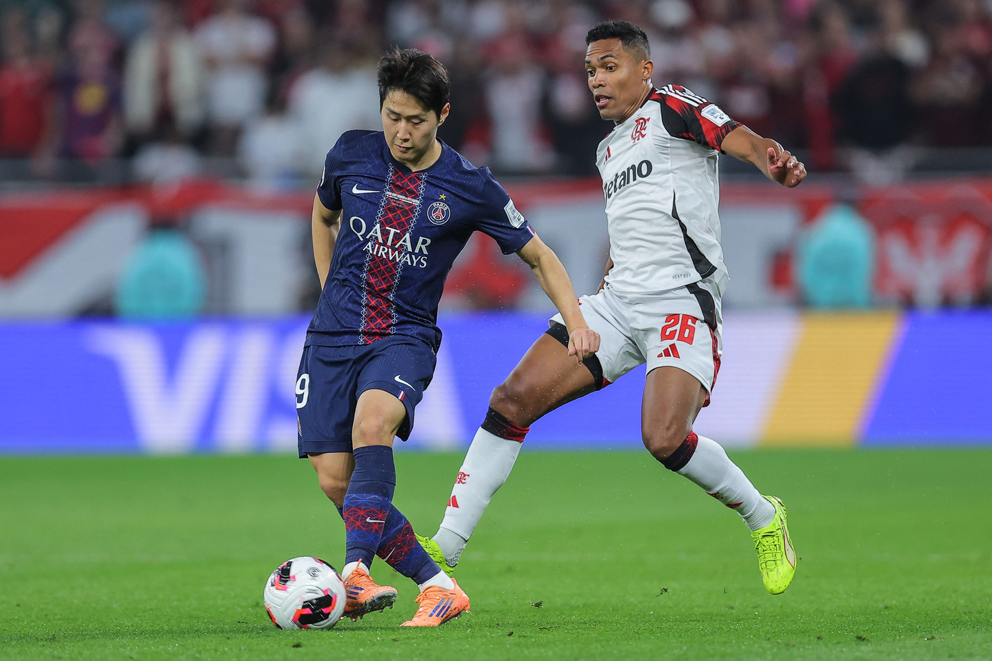 Lee Kang-in of Paris Saint-Germain, left, battles Alex Sandro of CR Flamengo for the ball during the final of the FIFA Intercontinental Cup at Ahmad bin Ali Stadium in Al Rayyan, Qatar, on Dec. 17. [AFP/YONHAP]