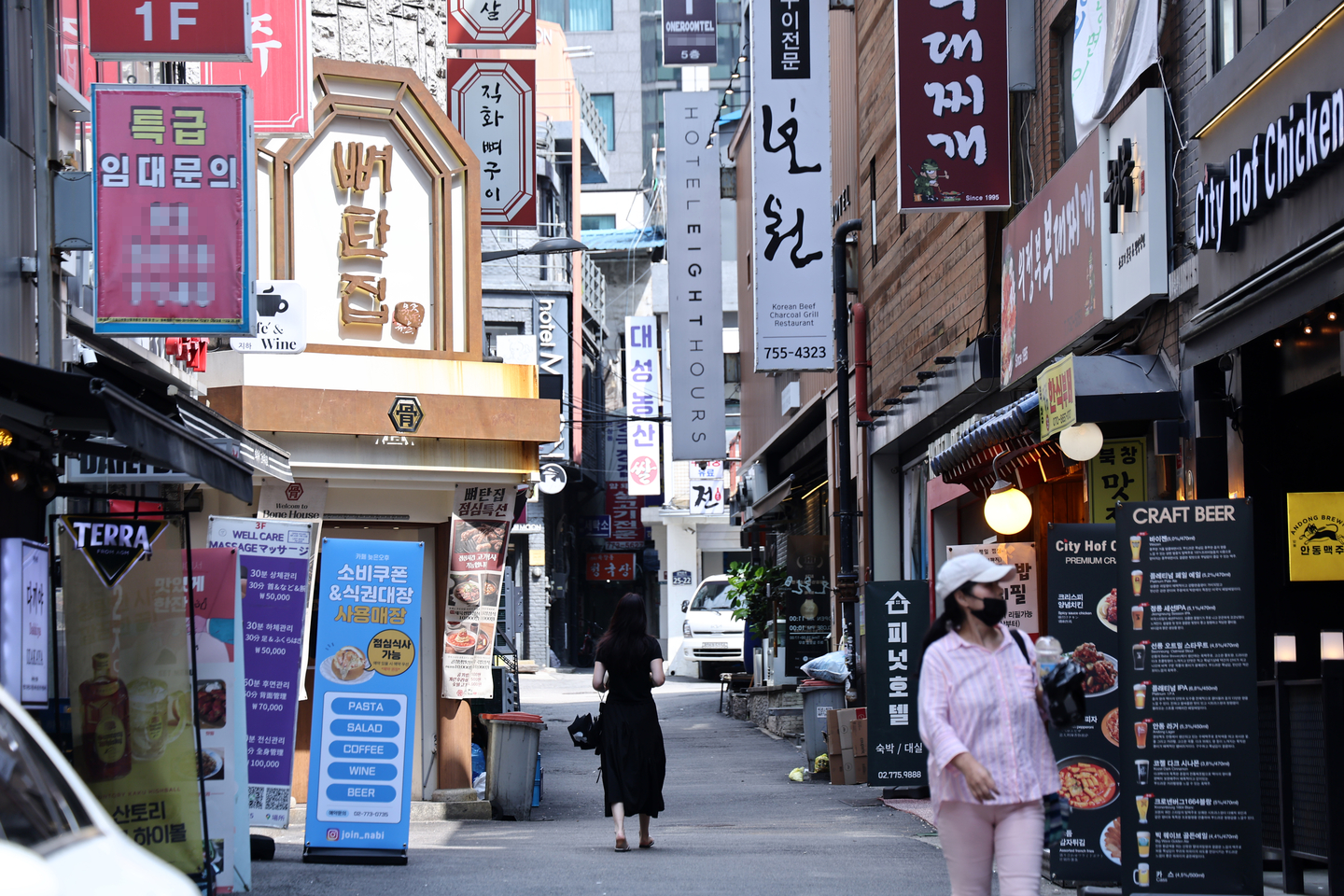 Pedestrians walk through an alley of restaurants in Jung District, central Seoul, on Aug. 18. [YONHAP] 