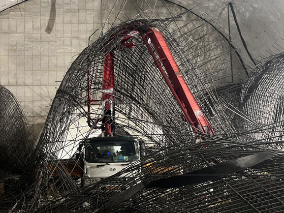 Piles of steel reinforcement bars lie tangled around a concrete pour truck and crane at the construction site of the Shinansan Line railway in Yeouido, western Seoul, on Dec. 18. Fire and police officials said the steel bars collapsed shortly after 1:20 p.m. at a tunnel located about 70 meters (230 feet) below ground, trapping two workers under the debris. A man identified as the driver of the vehicle was struck in the head and went into cardiac arrest before being rushed to a hospital. Authorities later confirmed he survived and is recovering. Officials said they are investigating the cause of the collapse. [NEWS1]