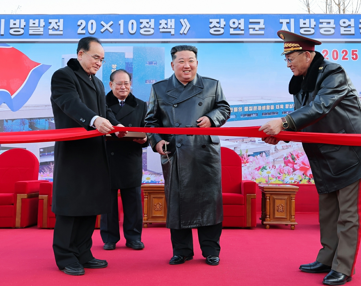 North Korean leader Kim Jong-un, center, cuts the ribbon at the inauguration ceremony for regional factories in Jangyon County, South Hwanghae Province, on Dec. 18, in this photo published by the Korean Central News Agency on Dec. 19. [KCNA]