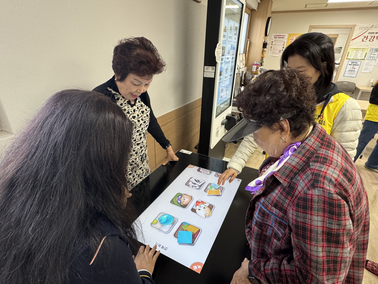 Seniors play games on a digital tabletop device at a smart senior center in Yangcheon District, western Seoul, on Nov. 4. [CHO JUNG-WOO]