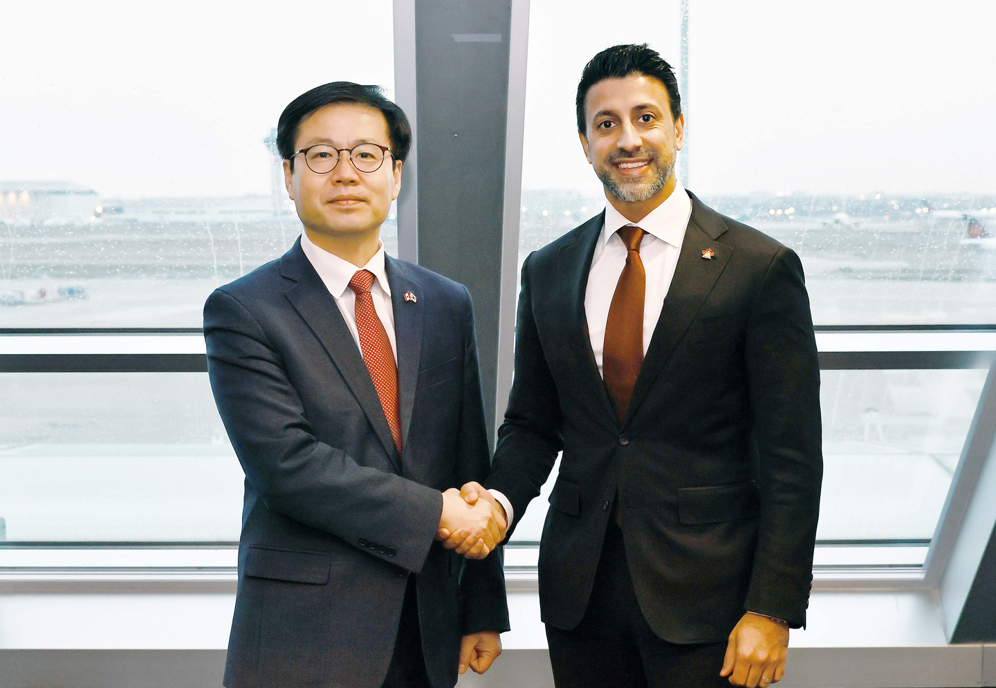Trade Minister Yeo Han-koo, left, poses for a photo with his Canadian counterpart, Maninder Sidhu, in Toronto on Dec. 18. [YONHAP] 