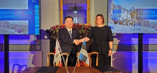 This photo provided by the Korea Trade-Investment Promotion Agency (Kotra) shows Kotra CEO and President Kang Gyeong-seong, left, and Katri Raudsepp, deputy director general of the Estonian Center for Defense Investments, shaking hands after signing a contract to export Chunmoo multiple rocket systems in Tallinn on Dec. 21. [YONHAP] 