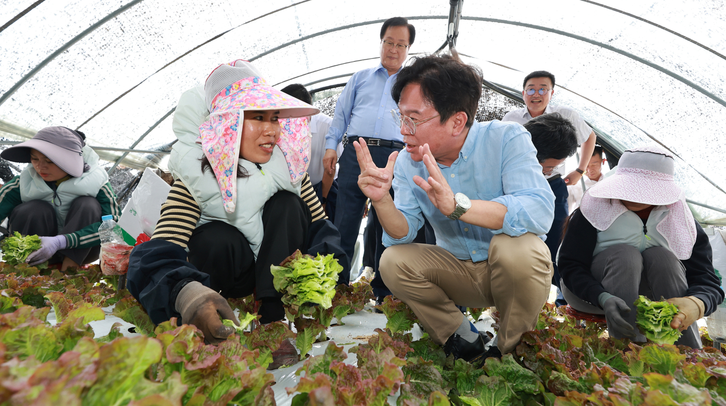 Labor Minister Kim Young-hoon listens to foreign workers during a visit with Democratic Party Rep. An Ho-young, chair of the National Assembly’s Environment and Labor Committee, to a farm employing foreign laborers in Wanju County, North Jeolla, on Aug. 8. [MINISTRY OF EMPLOYMENT AND LABOR]