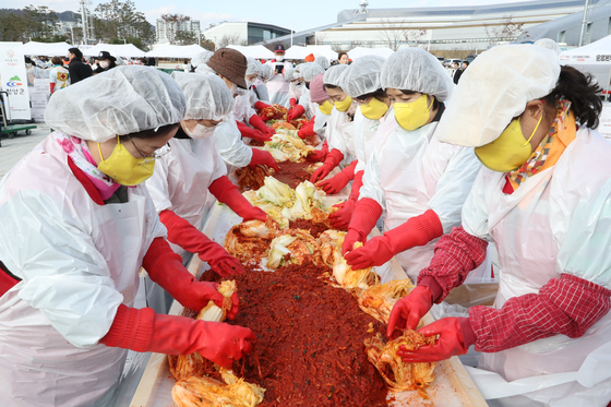 Volunteers prepare kimchi to be delivered to underprivileged residents at a plaza in South Chungcheong on Nov. 18. [YONHAP]