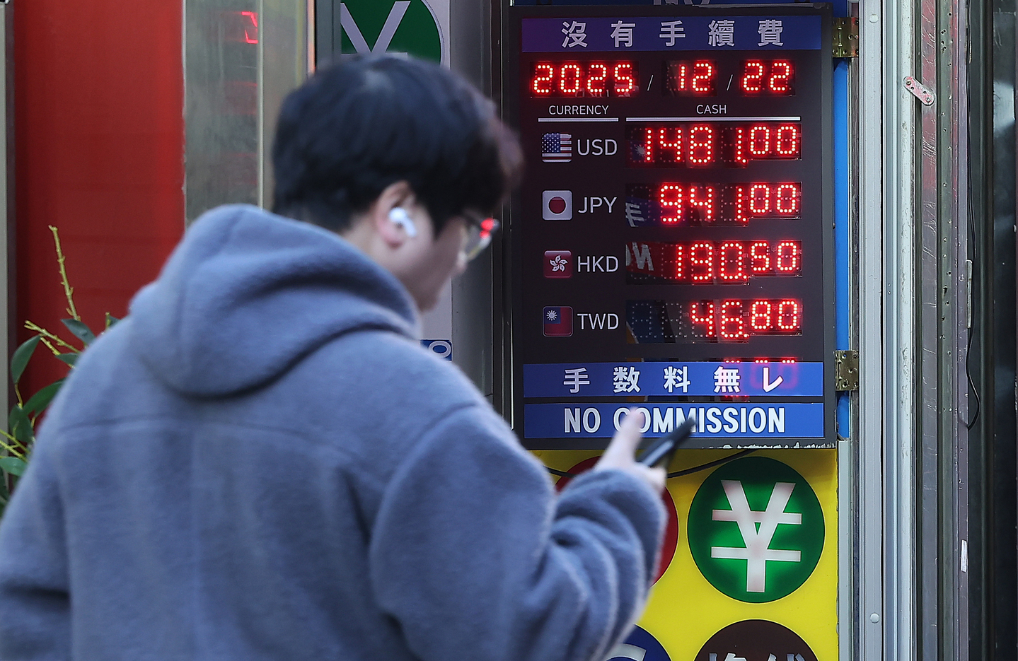 A pedestrian passes a currency exchange booth in Myeongdong, central Seoul, on Dec. 22, as the won-dollar exchange rate continues its upward trend. [NEWS1]