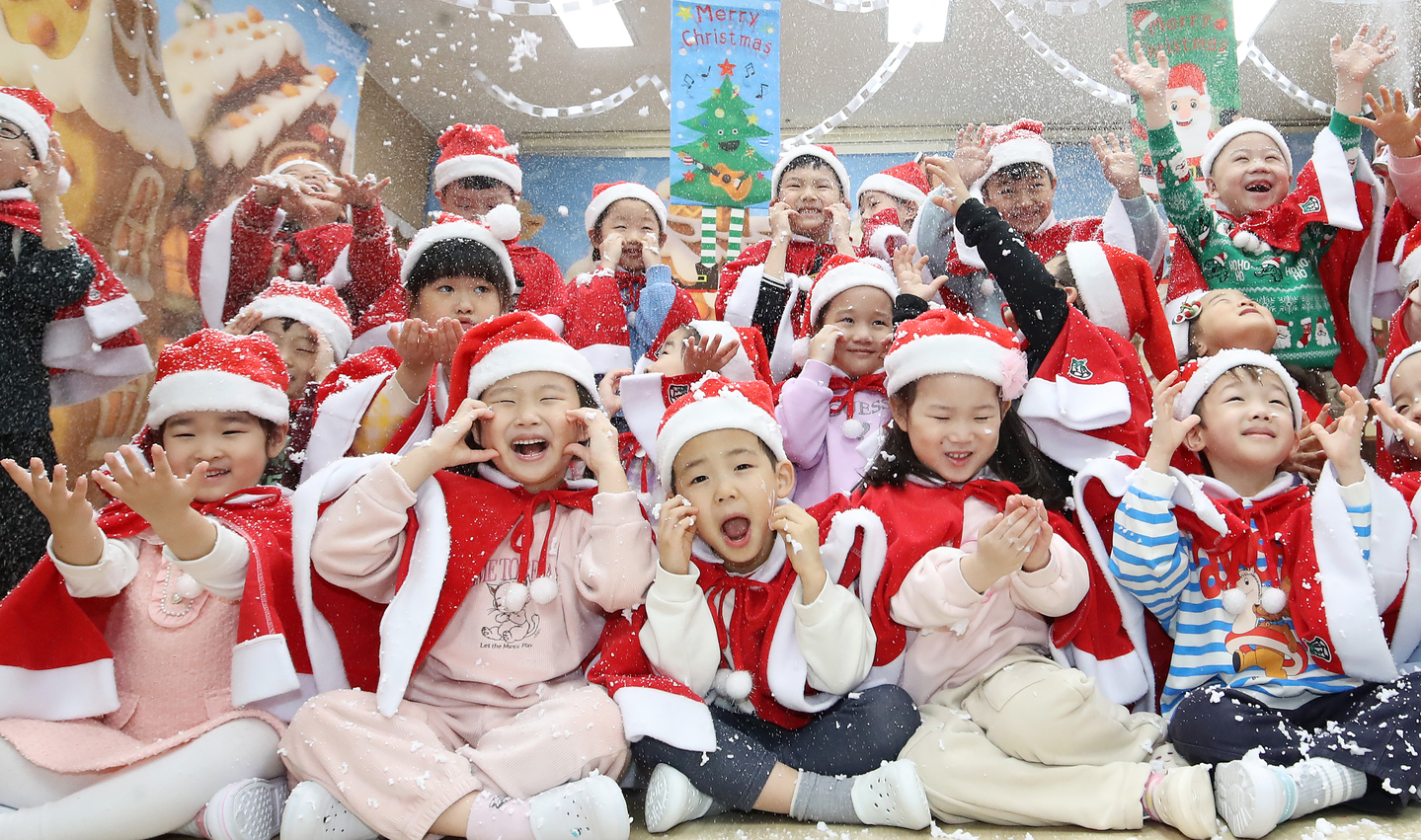 Children dressed as Santas play under artificial snow at the daycare center inside Busanjin District Office, in Busan, on Dec. 23, soaking up the holiday spirit. [NEWS1]