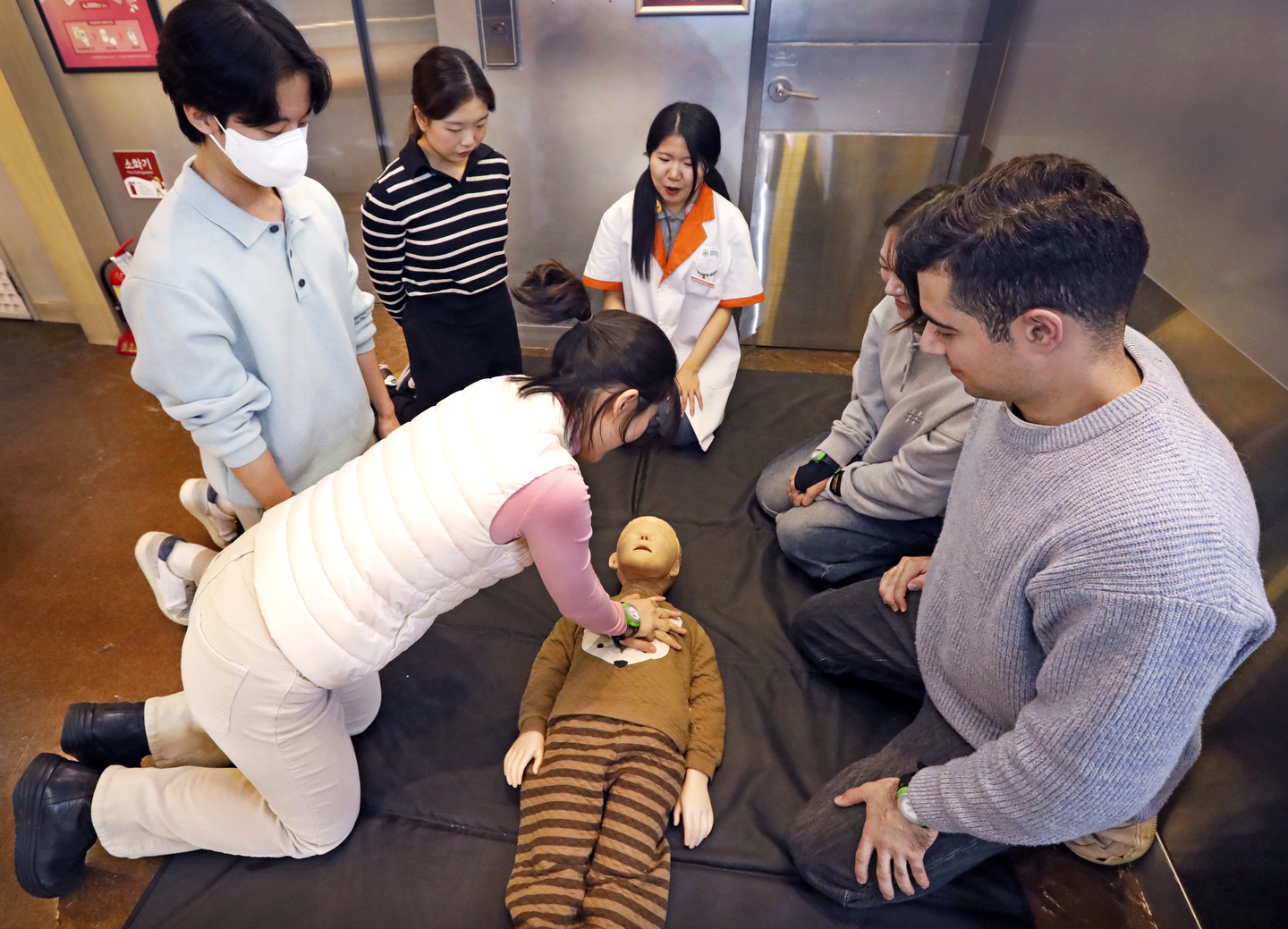 A woman performs cardiopulmonary resuscitation (CPR) on a doll named James during a role-playing event for adults at KidZania in Jamsil, southern Seoul, on Dec. 20. [PARK SANG-MOON]