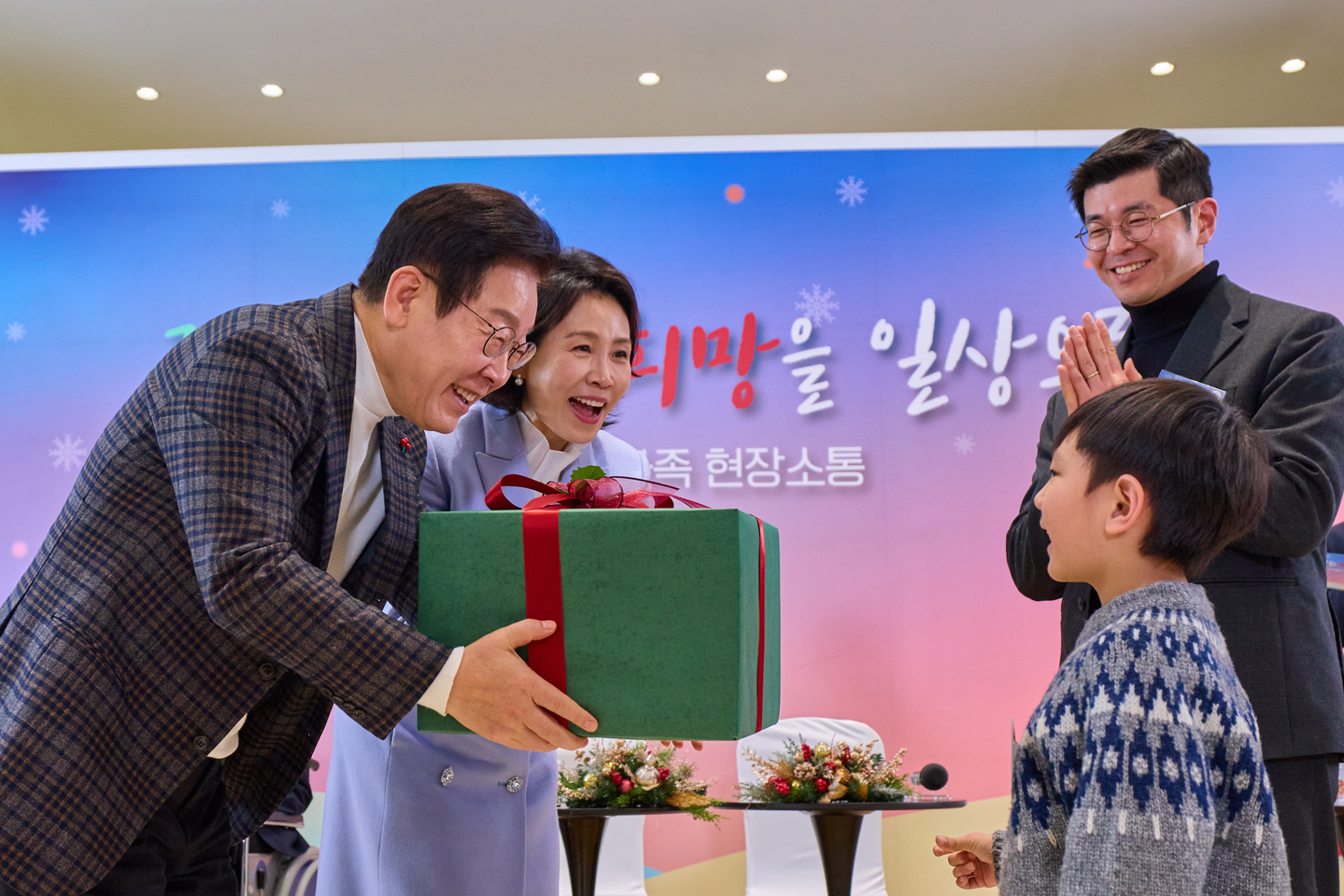 President Lee Jae Myung, left, and first lady Kim Hea Kyung, second from left, give a present to a patient at Severance Hospital in Seoul on Dec. 24. [YONHAP] 