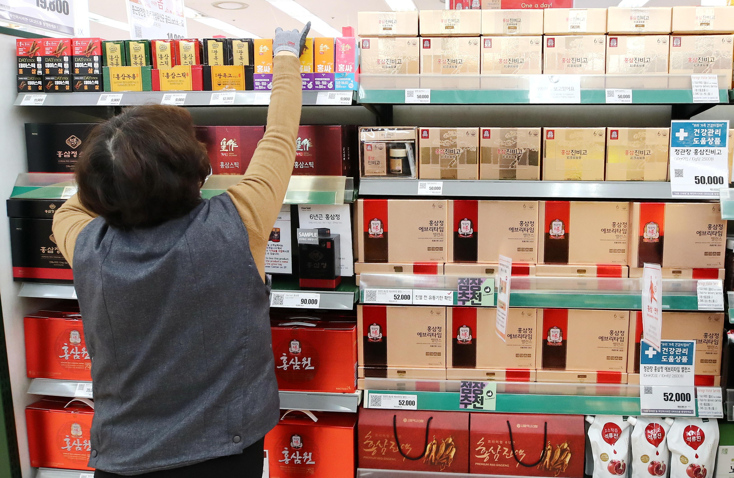 A worker stocks health supplements and red ginseng products on a shelf at a supermarket in Seoul on March 2, 2020. [YONHAP] 