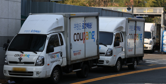 Delivery vehicles sit parked at a Coupang logistics center in Seoul on Dec. 7. [NEWS1]