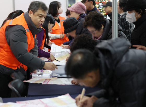 Older people are seen filling out job applications at a job fair held at Mapo District Office in Mapo District, western Seoul, on Dec. 10. [YONHAP] 