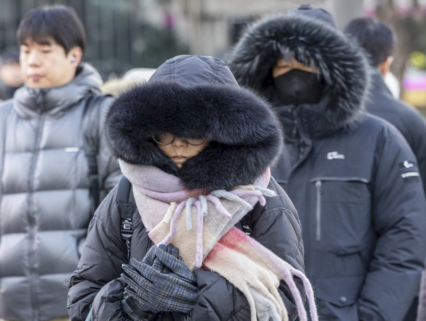 People walk at the Sejong-daero intersection in Gwanghwamun in central Seoul on the morning of Dec. 26, as a cold wave warning remains in effect. [JOONGANG ILBO]