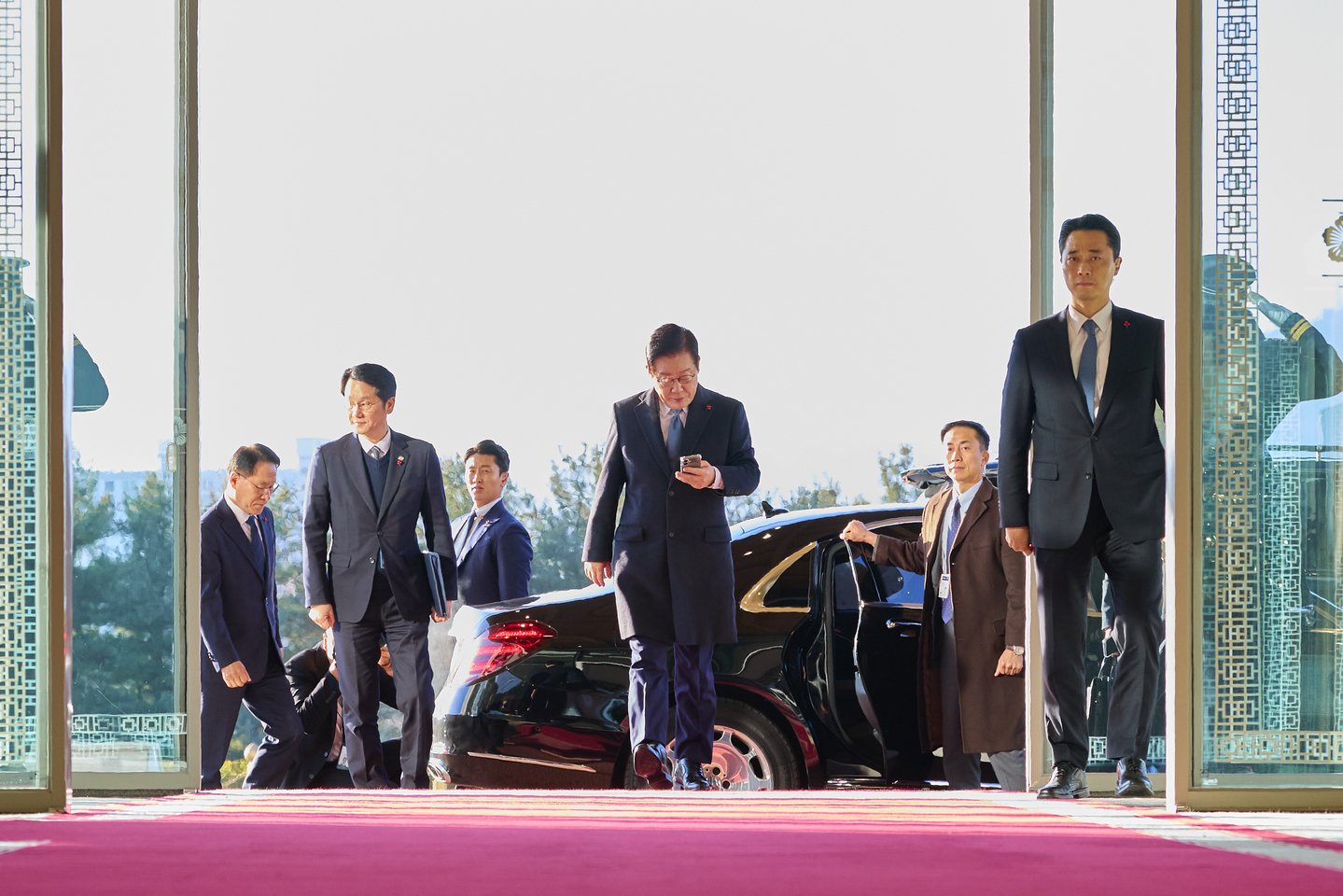President Lee Jae Myung, center, enters the presidential office building in Seoul's Yongsan district on Dec. 26, marking his last day at the office, in this photo provided by Lee's office. [YONHAP] 