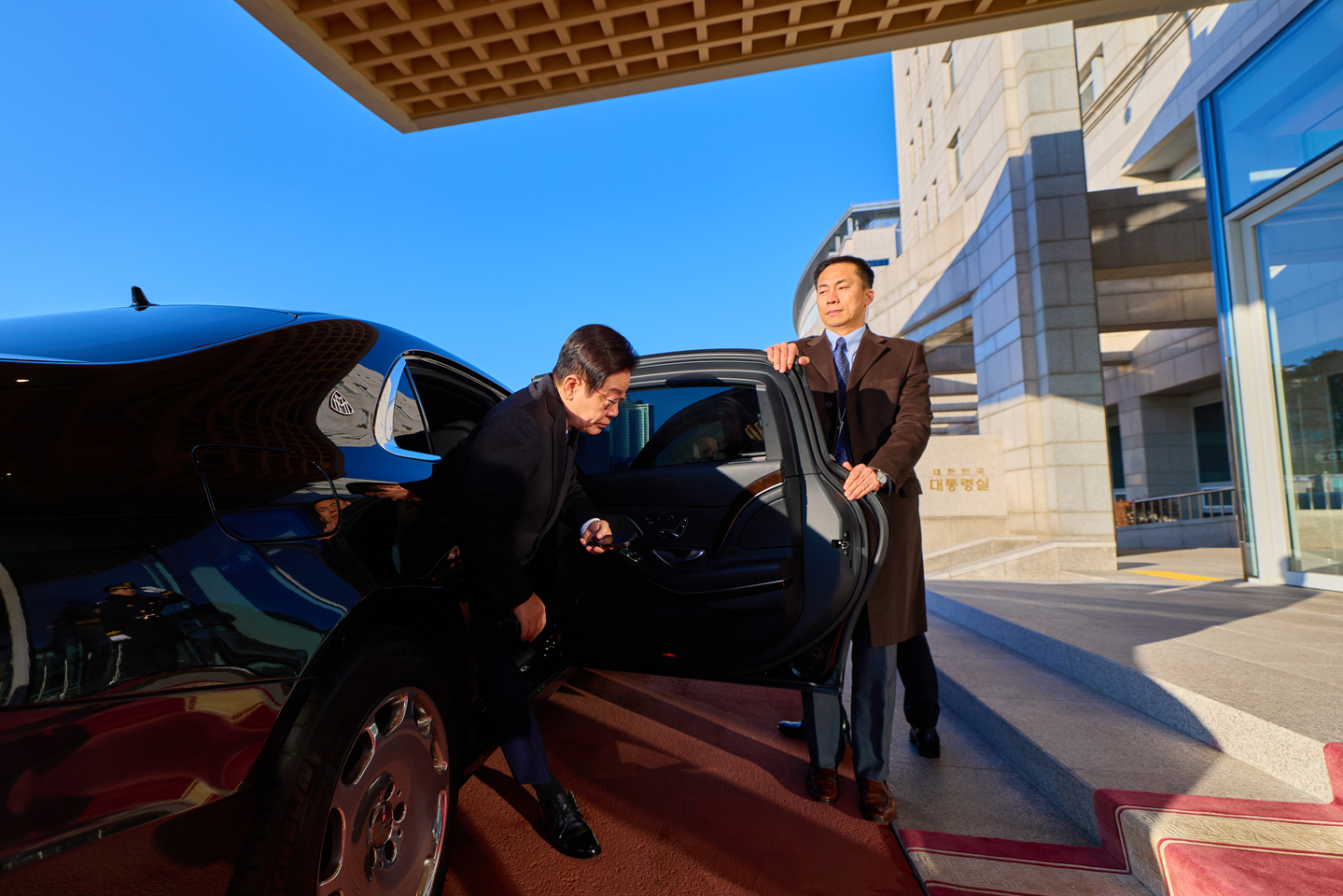 President Lee Jae Myung, left, steps out from a car to spend his last day at the presidential office building in Seoul's Yongsan district on Dec. 26, in this photo provided by Lee's office. [YONHAP] 
