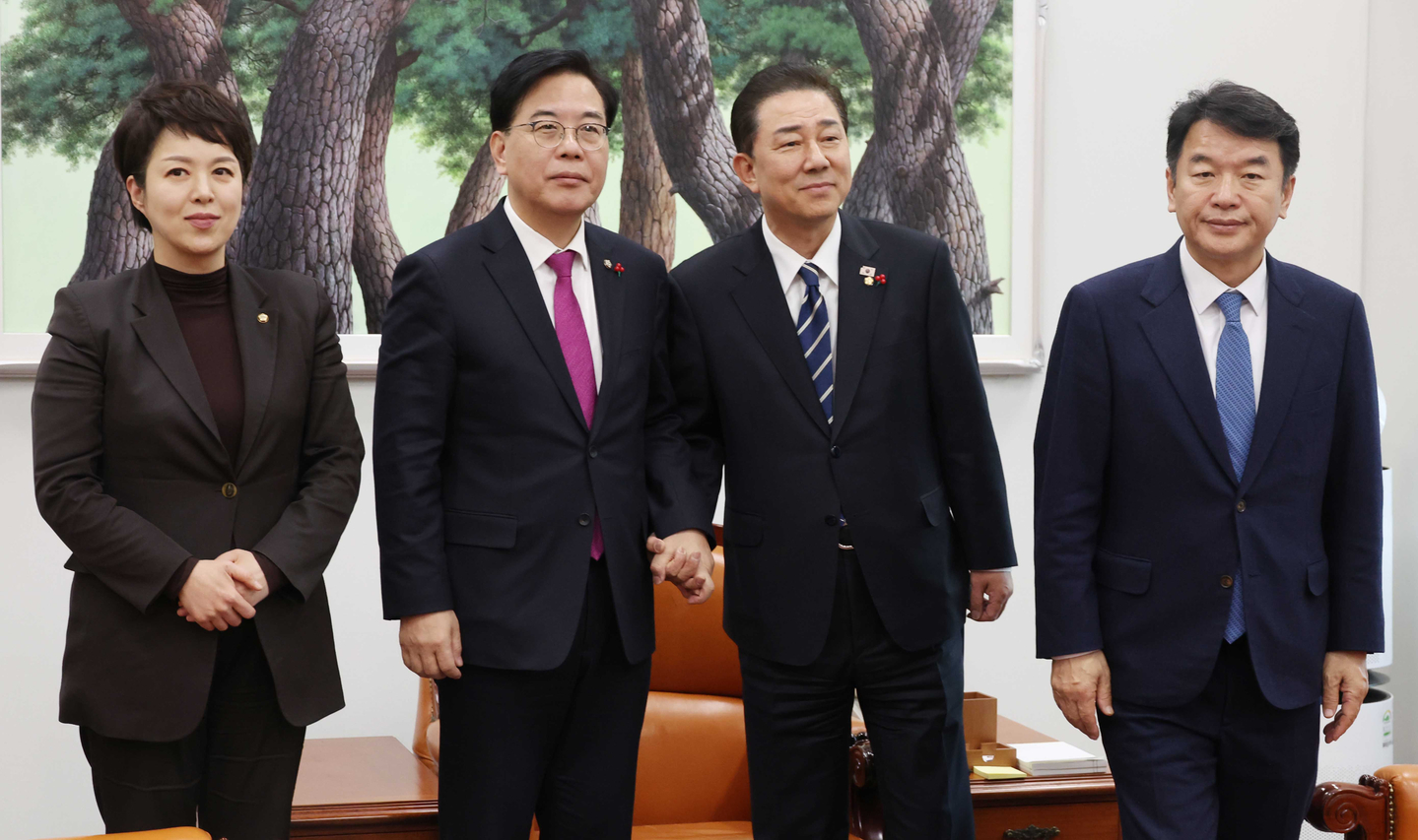 Kim Byung-kee, the floor leader of the Democratic Party, center right, and Song Eon-seog, the floor leader of the People Power Party, center left, pose for reporters while shaking hands during a meeting of floor leaders on pending issues, including a special counsel probe into the Unification Church, at the National Assembly in Yeouido, western Seoul, on Dec. 22. Kim Eun-hye, the senior policy deputy floor leader of the People Power Party, stands to Song's left, and Moon Jin-seog, the senior floor operations deputy leader of the Democratic Party, to Kim's right. [YONHAP]
