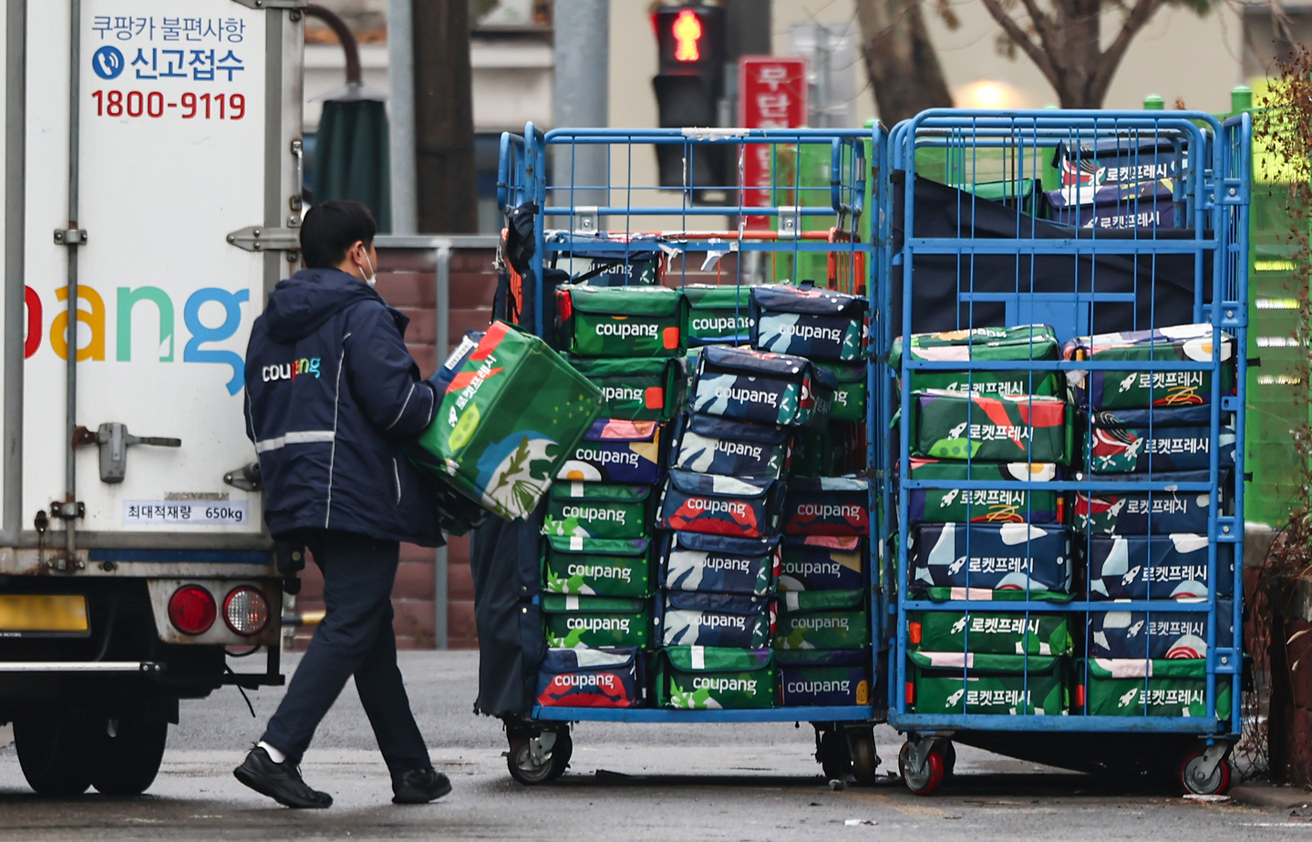 A Coupang deliveryperson is seen moving packages at a warehouse in Seoul on Dec. 16.. [NEWS1]