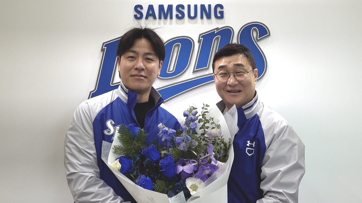 Samsung Lions catcher Kang Min-ho, left, poses with general manager Lee Jong-yeol after signing a two-year contract with the club in free agency on Dec. 28. [SAMSUNG LIONS]