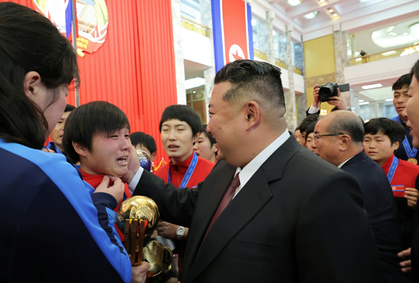 North Korean leader Kim Jong-un, center, meets with female footballers and coaches who won the 2025 FIFA U-17 Women's World Cup earlier this year during a ceremony held in Pyongyang to mark Constitutional Day on Dec. 27. [KOREAN CENTRAL NEWS AGENCY]