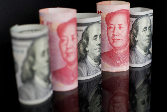 Banknotes of Chinese yuan and U.S. dollar are seen in this illustration. [REUTERS/YONHAP]