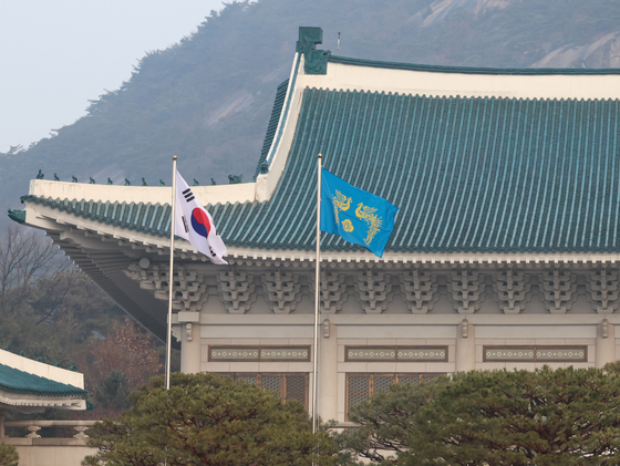 The phoenix flag and the Korean flag flutter in the wind in front of the Blue House’s main building in central Seoul on Dec. 29. [YONHAP]