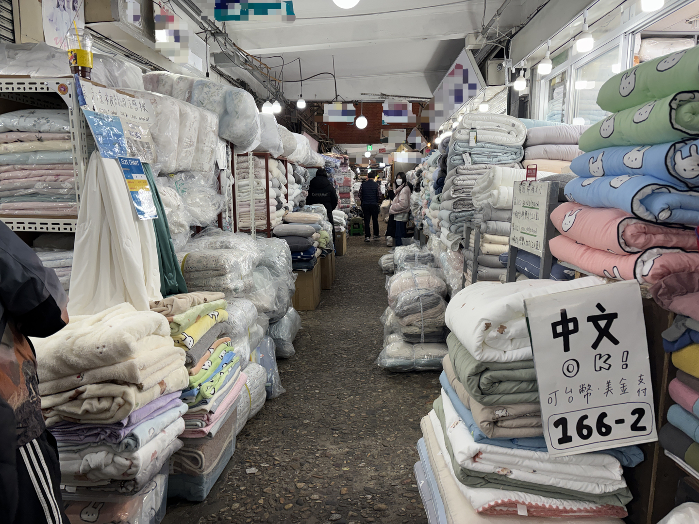Signs announcing that New Taiwan dollars and U.S. dollars are accepted are put up in the ″blanket alley″ in Gwangjang Market in Jongno District, central Seoul, on Dec. 22. [KWAK JOO-YOUNG]