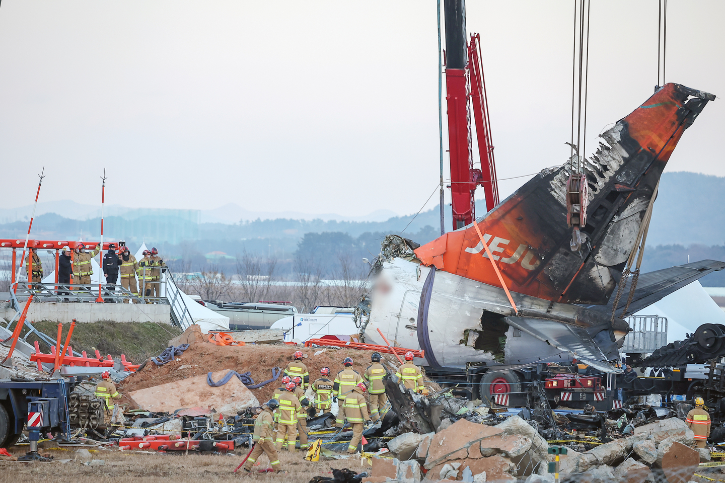 The tail section of the aircraft in the Jeju Air disaster is lifted by a crane at the crash site at Muan International Airport in South Jeolla on the afternoon of Jan. 3, six days after the crash. [NEWS1]