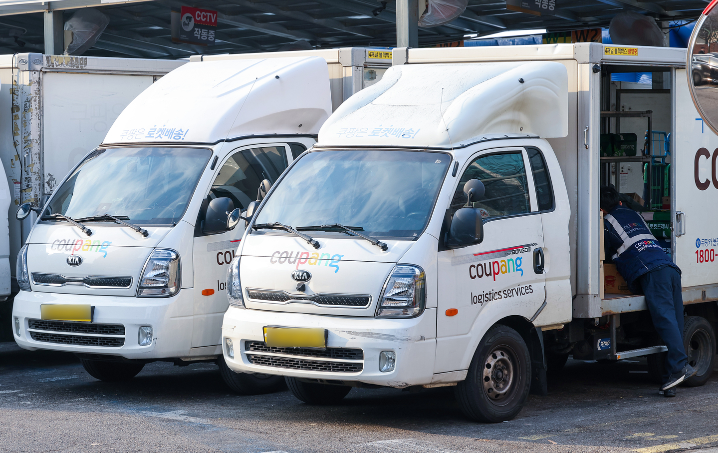 A Coupang delivery worker is seen moving packages from a delivery truck in Seoul on Dec. 28. [WOO SANG-JO]