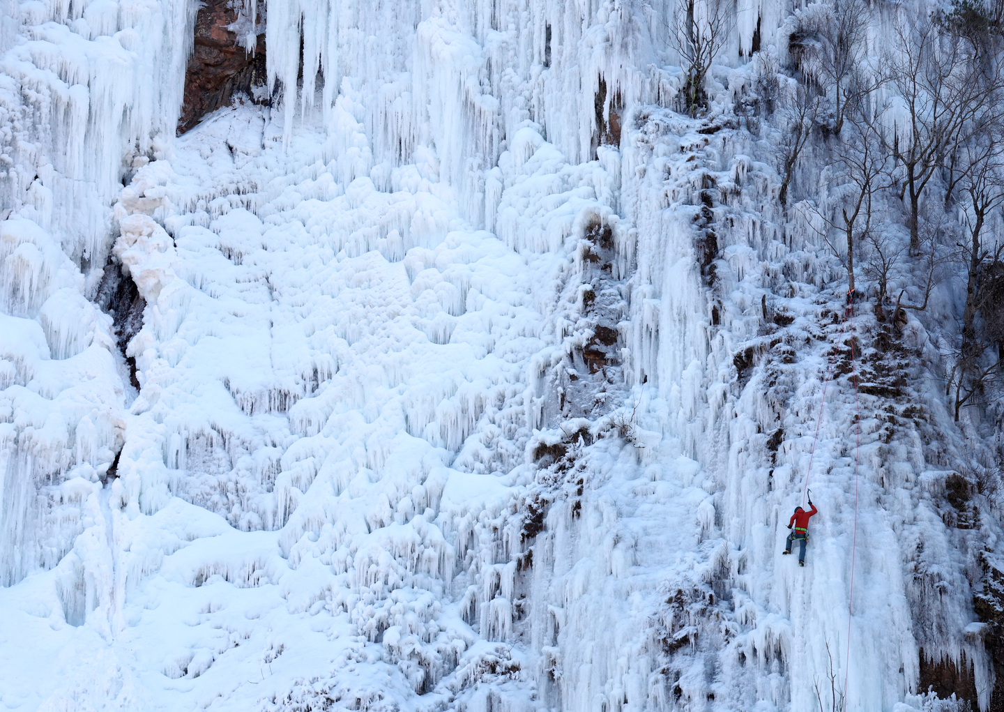 A climber ascends the frozen face of Maebawi Falls in Yongdae-ri, Buk-myeon, Inje County, relying on a safety rope to push past winter’s limits as a cold wave grips much of the nation on Dec. 30. [YONHAP]