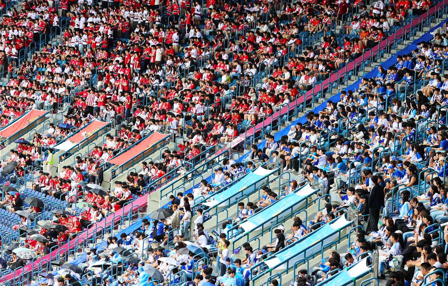 Students from Korea University, left, and Yonsei University cheer while watching a baseball game during the two schools' annual intercollegiate games at Jamsil Baseball Stadium in Songpa District, southern Seoul, on Sept. 19. [YONHAP]
