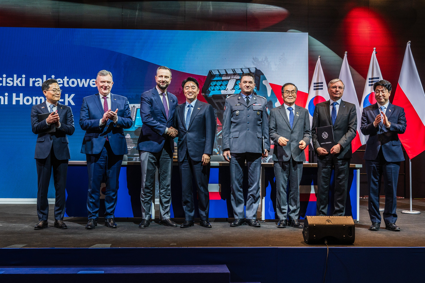 Key officials from the Korean and Polish governments and Hanwha Aerospace, including Son Jae-il, CEO and President of Hanwha Aerospace, far left, and Presidential chief of staff Kang Hoon-sik, fourth from left, pose for a commemorative photo during the signing ceremony for the third executive contract for Hanhwa's Chunmoo guided missile. [HANWHA AEROSPACE]
