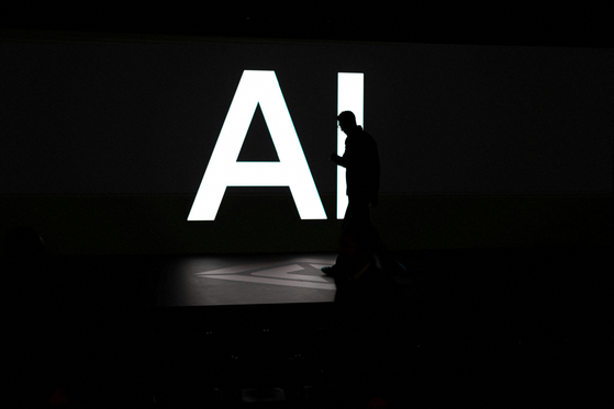 A screen reads 'AI' in reference to artificial intelligence as attendees gather during Rivian's first Autonomy and AI Day, showcasing developments in self-driving technology, in Palo Alto, California, on Dec. 11. [REUTERS/YONHAP]